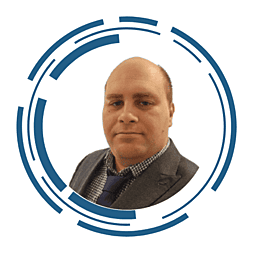 A headshot of Stuart Carter, he is wearing glasses and has a beard